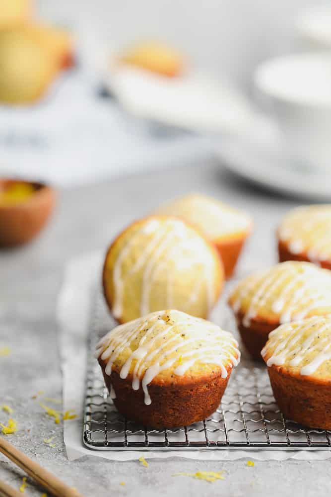 many muffins on a cooling rack with grey background