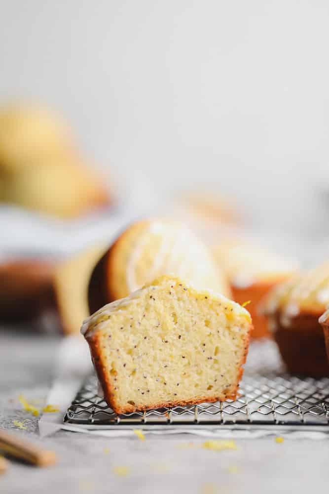 a muffin cut in half showing the texture, lemon poppy seed flavor