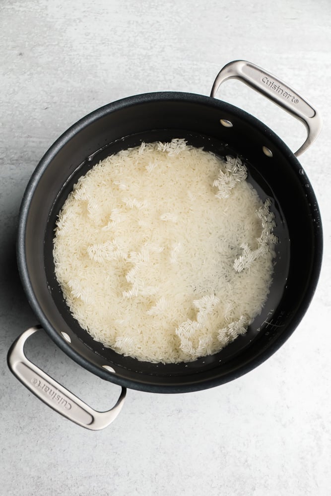 white rice and water in a black pot