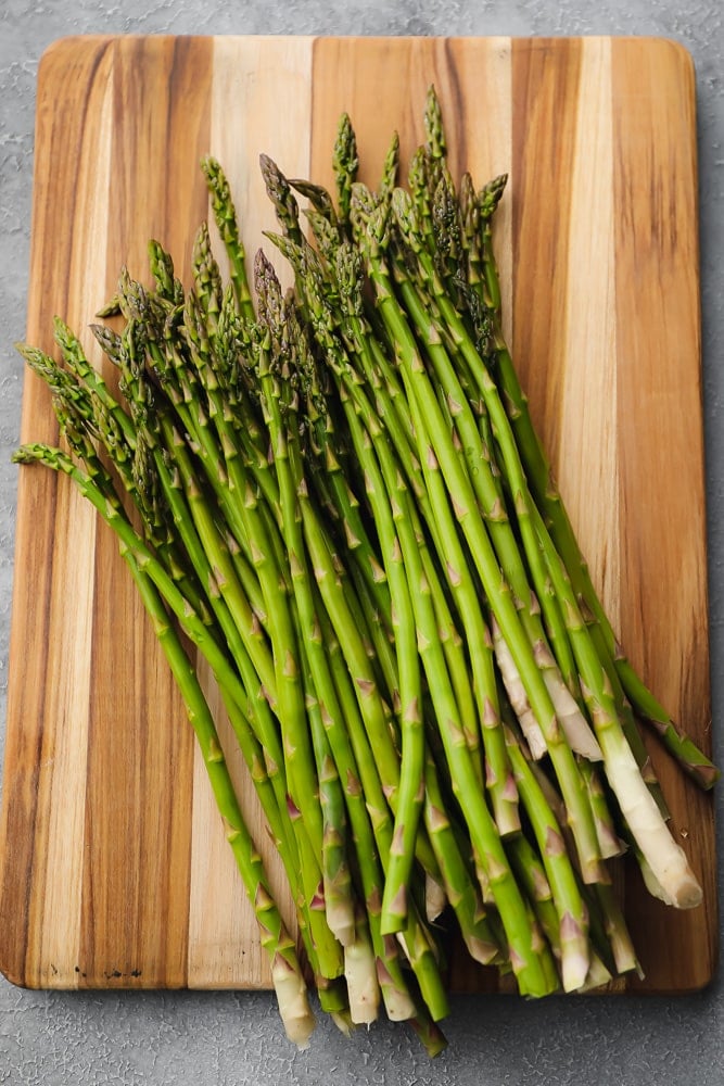 raw asparagus on a wood board