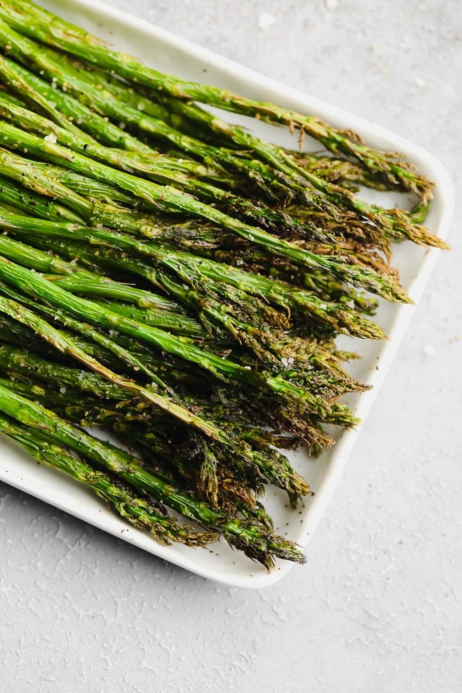 cooked asparagus on a white serving plate