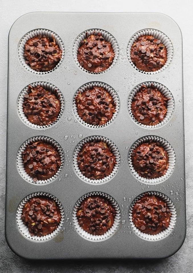 unbaked chocolate batter in a lined muffin tin