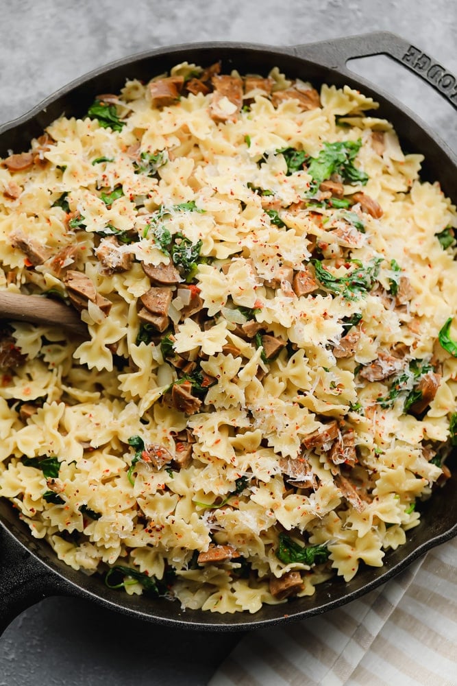 looking down on a pan with pasta, spinach and cheese