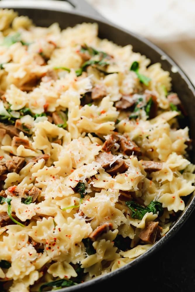 a cast iron pan full of pasta and sausage