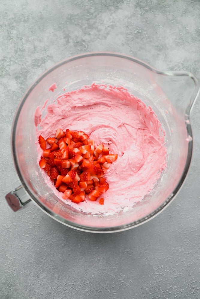 bowl with pink cupcake batter and strawberry pieces