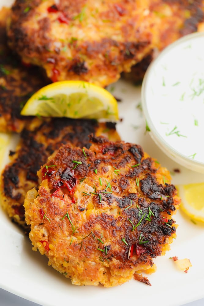 close up on a pile of fried crab cakes on a white plate