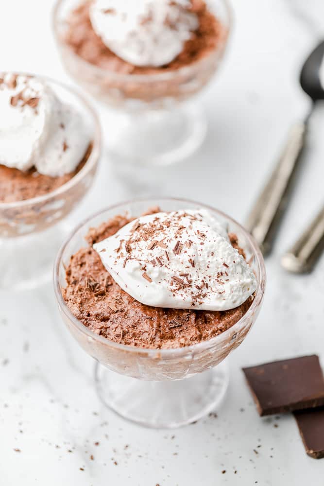 3 glass dessert cups with chocolate mousse and whipped cream