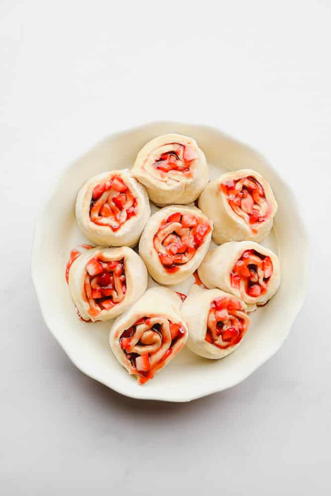 rolls with strawberries, unbaked in a white dish