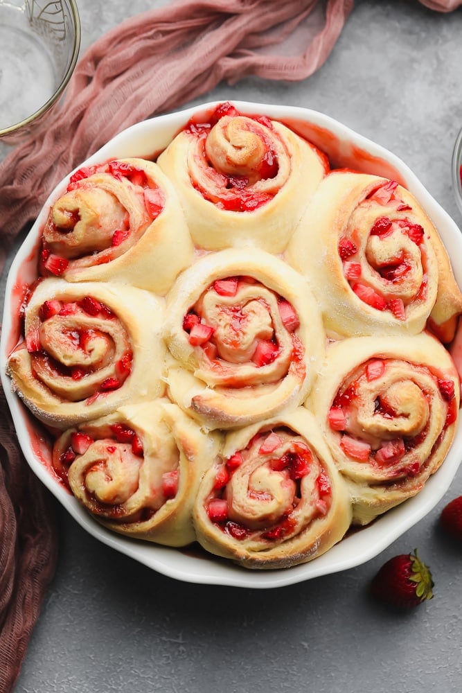 many berry filled cinnamon rolls in a round dish, cooked