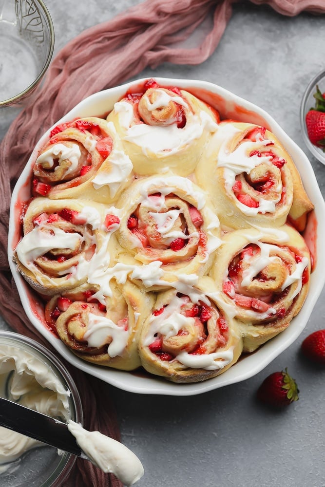 cooked strawberry rolls with icing in dish