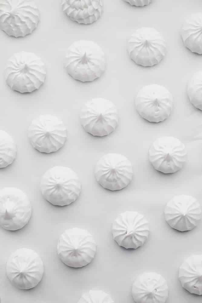 white meringue cookies on parchment paper