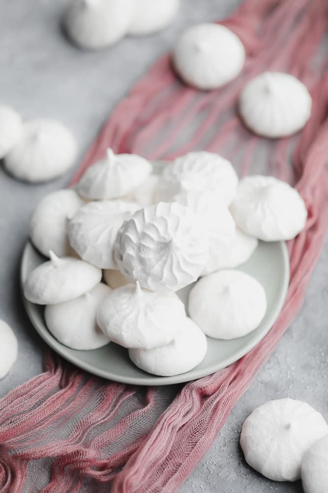 White vegan meringues cookies on a small grey plate