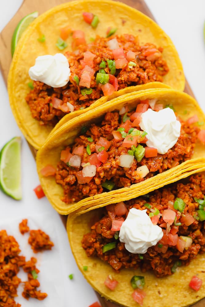 3 corn tortilla tacos on a wood serving platter