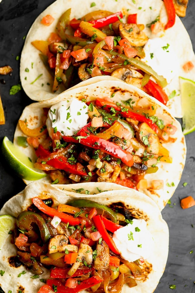 3 tortillas in a row stuffed with sauteed bell peppers, onions, and mushrooms