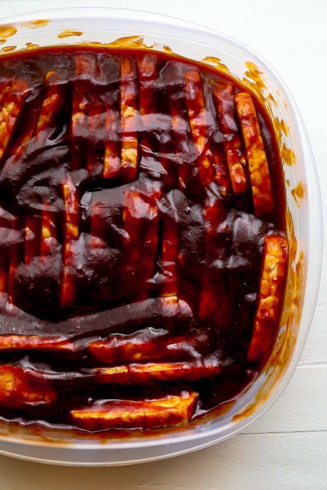 tempeh marinating in a dish with bbq sauce