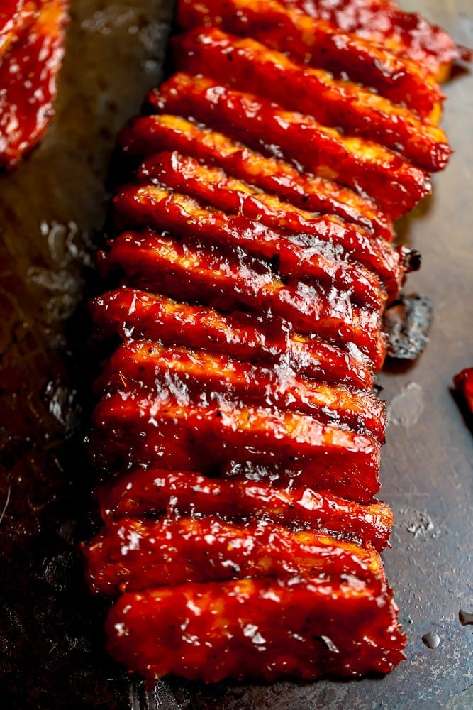 many tempeh pieces with bbq sauce on a pan