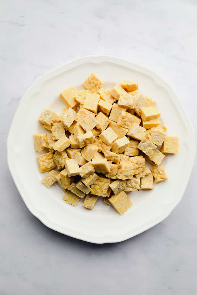 cubes of beige tempeh on a white plate