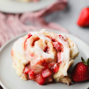 square image of a roll with strawberries on a plate