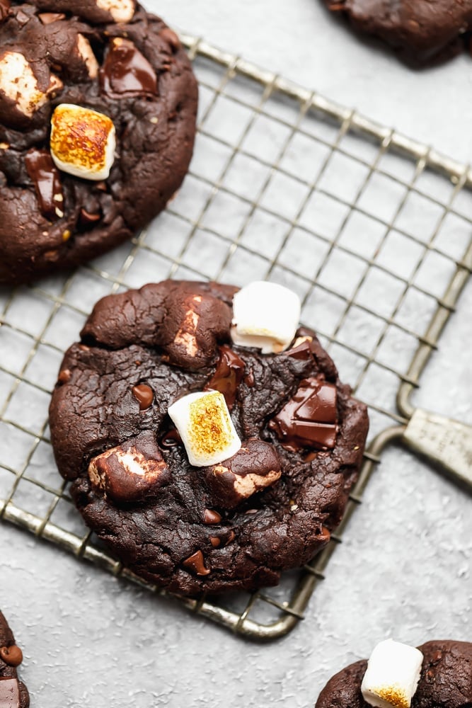 close up on 2 chocolate marshmallow cookies on a wire cooling rack