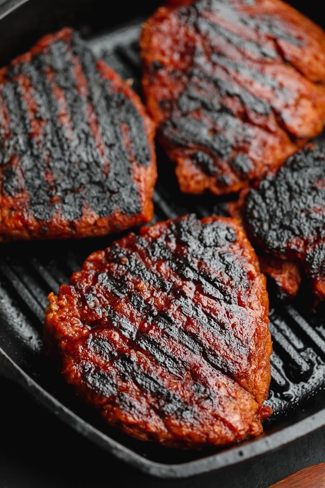 4 charred vegan steaks in a black grill pan