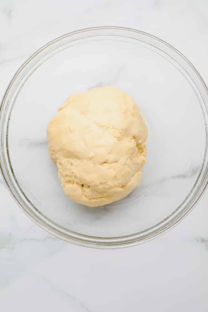 small ball of raw bread dough in a glass bowl