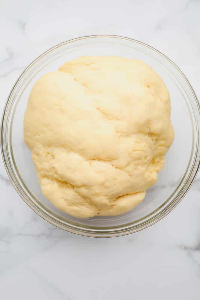 large ball of raw bread dough in a glass bowl