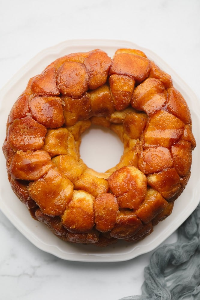 baked golden brown monkey bread in a circle on a white plate