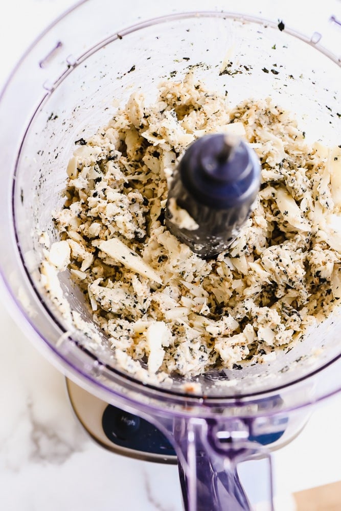 white mixture with green flecks in a food processor