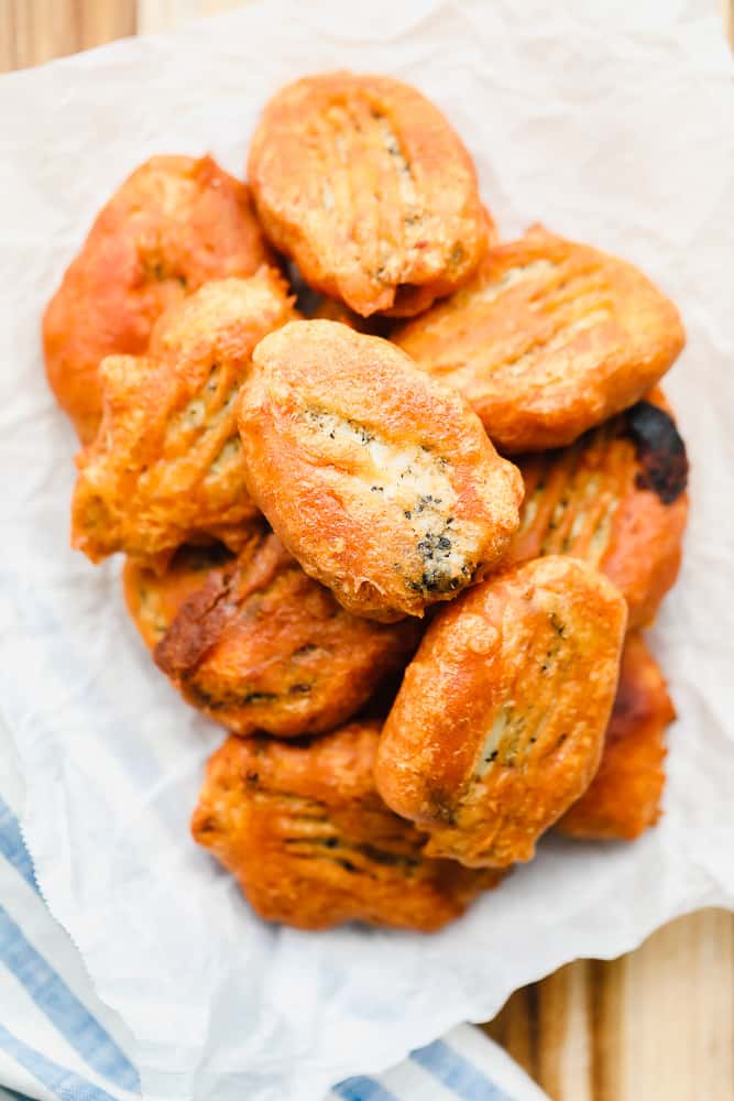 piles of golden brown vegan fried fish on a piece of white parchment paper