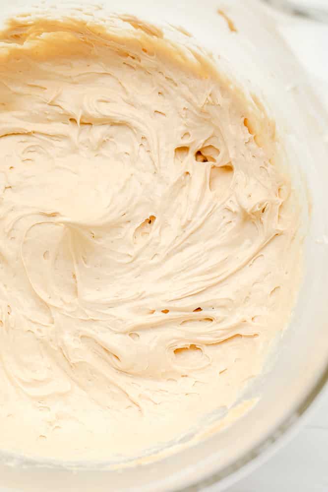 glass bowl filled with a beige, creamy peanut butter mousse