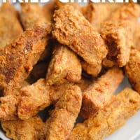 pinterest image of a large plate filled with golden brown fried vegan chicken pieces
