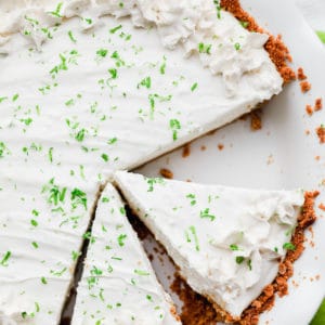 cut slices of key lime pie in a white pie plate