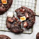 close up on a chocolate marshmallow cookie split in half on a wire cooling rack