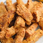 close up on a large plate filled with golden brown fried vegan chicken pieces