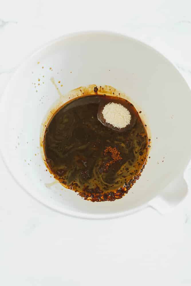 dark brown liquid with white sugar in a large white bowl