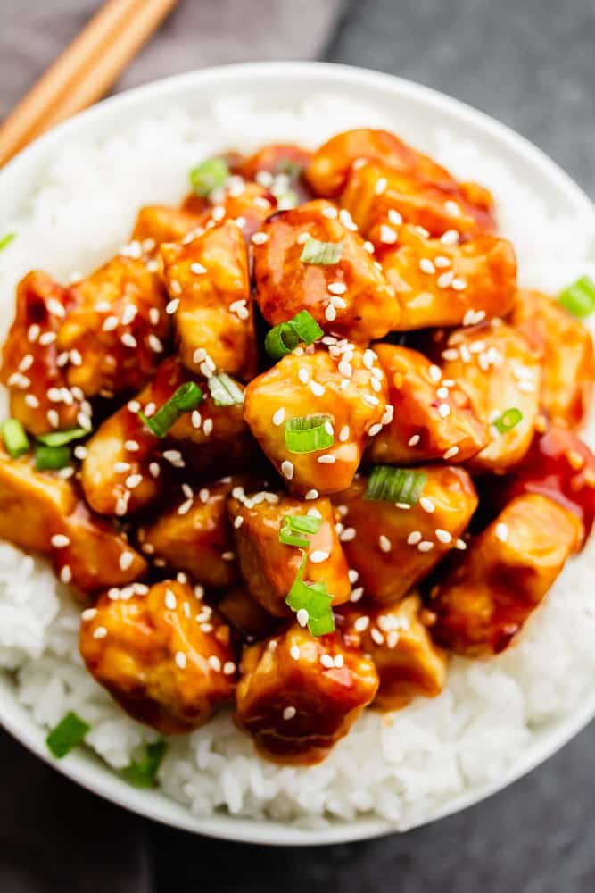 lots of tofu in sauce over white rice with sesame seeds