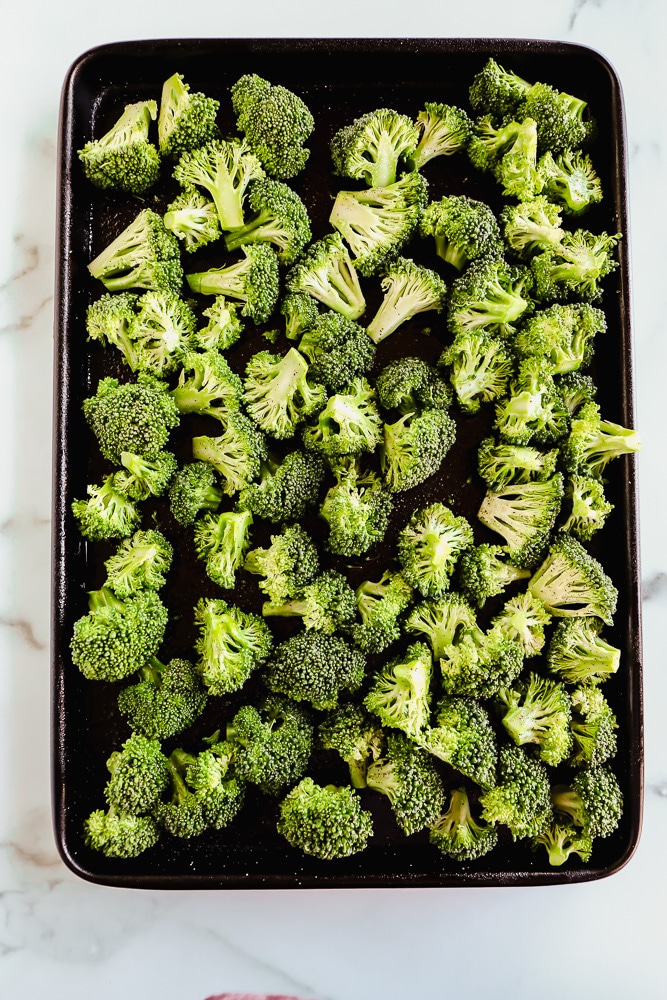 Raw broccoli florets on a baking sheet