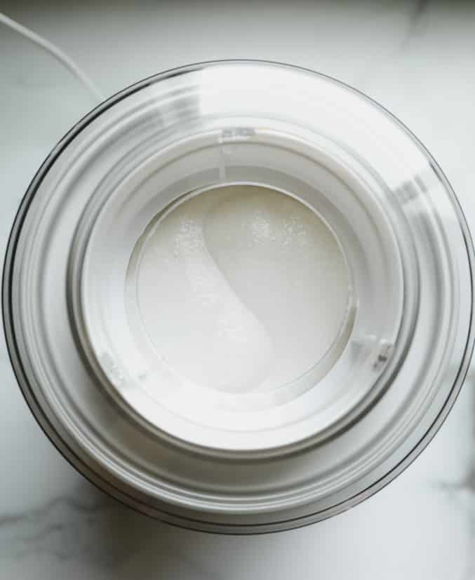 overhead view of an ice cream maker with a white creamy mixture inside