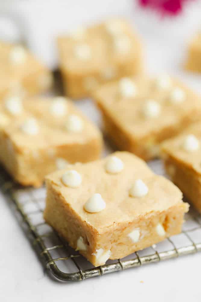 baked blondies cut into squares sitting on a wire rack