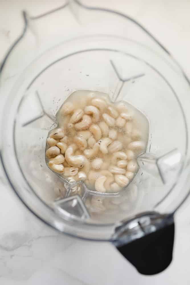 overhead view of cashews and water in a blender