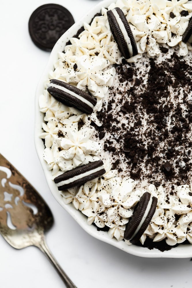 overhead view of an oreo cookie cake with piped white icing and crumbled cookies on top.