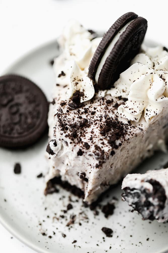 close up on a slice of oreo cheesecake with a bite missing