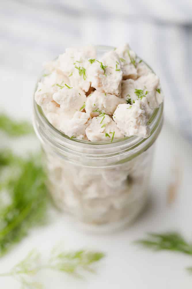 crumbled white pieces of vegan feta cheese in a glass jar