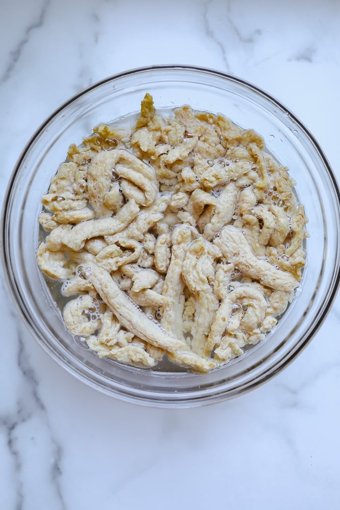 soy curls soaking in a bowl of water.