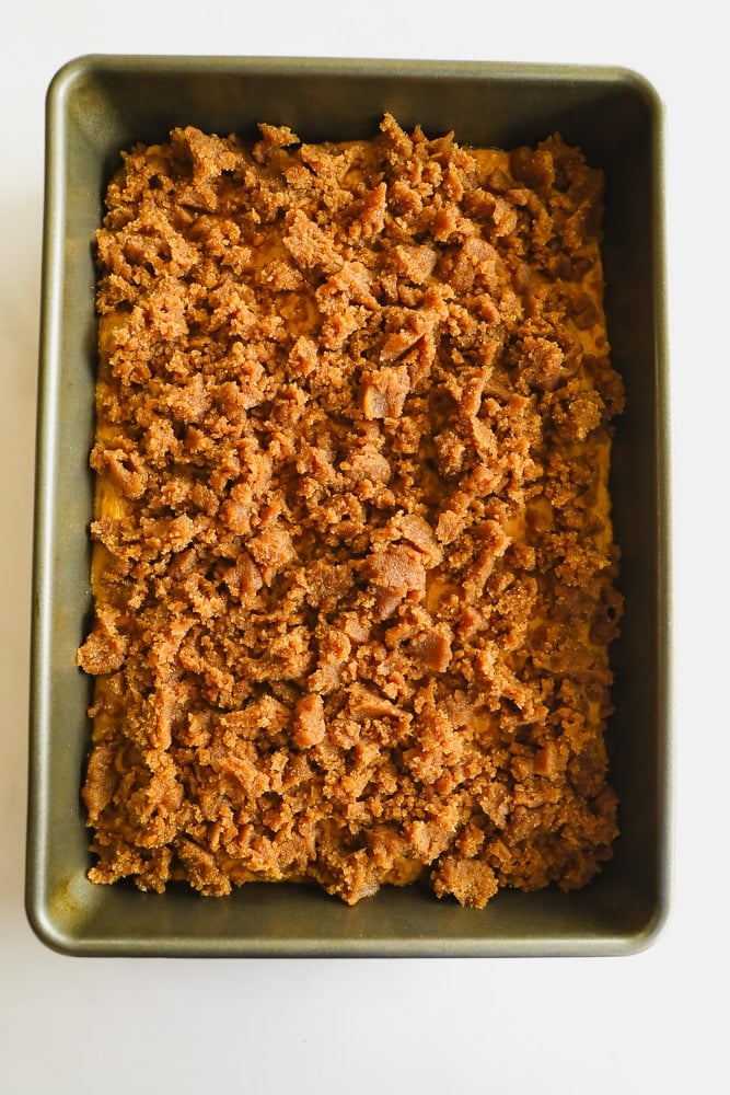 Crumbly brown streusel in a square metal baking dish.