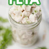 pinterest image of crumbled white pieces of vegan feta cheese in a glass jar