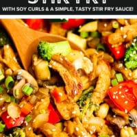 pinterest image of a wooden spoon scooping vegetables and soy curls from a stir fry