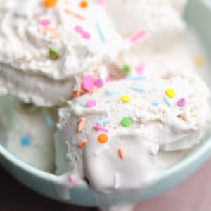 close up on scoops of vanilla ice cream with sprinkles in a bowl