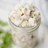 crumbled white pieces of vegan feta cheese in a glass jar