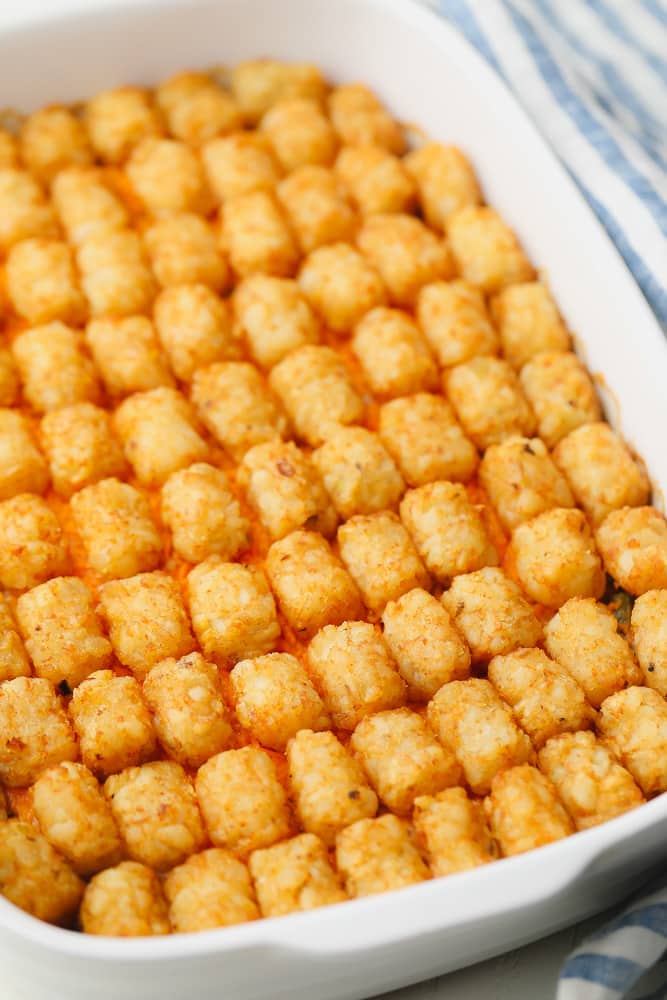 rows of baked tater tots in a white casserole dish.